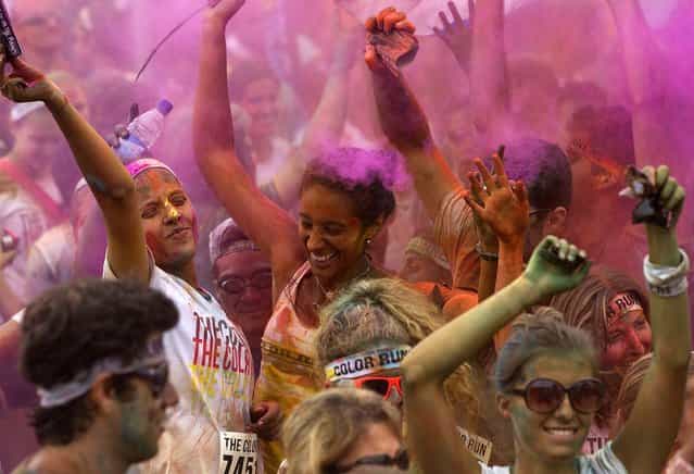People dance after The Color Run 5K in Rio de Janeiro, December 16, 2012. (Photo by Silvia Izquierdo/Associated Press)