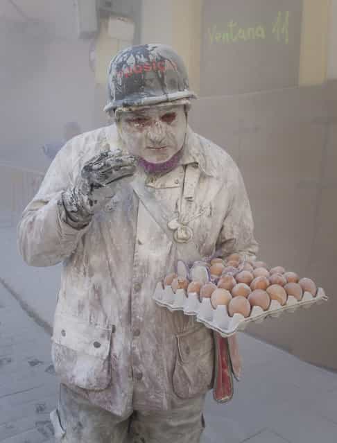 A military dressed man holding eggs takes part in the battle of [Enfarinats], a floor fight in the town of Ibi, in the south-eastern Spain on December 28, 2012. For 200 years Ibi's citizens annually celebrate with a battle using flour, eggs and firecrackers outside the city townhall. (Photo by Jaime Reina/AFP Photo)
