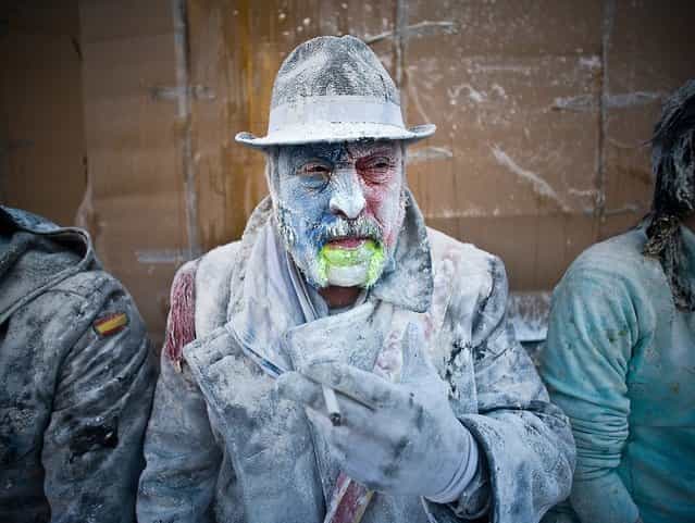 A Reveller smokes during the battle of [Enfarinats], a flour fight in celebration of the Els Enfarinats festival. (Photo by David Ramos)