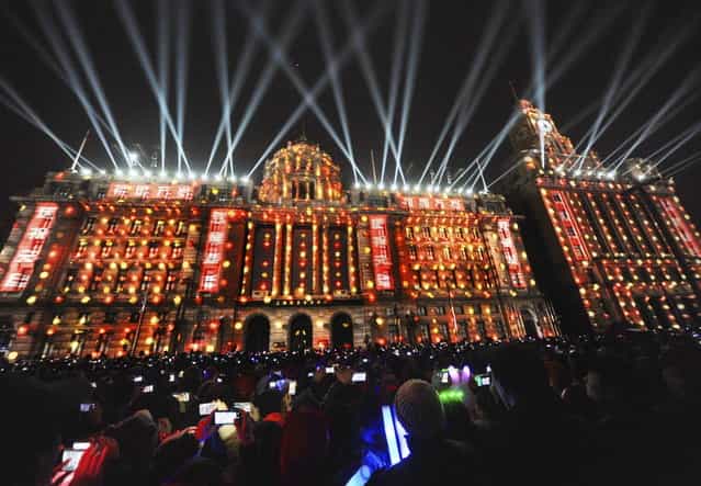 Visitors take pictures and videos during a light show as part of a New Year countdown celebration at the financial square on the Bund in Shanghai December 31, 2012. Picture taken December 31, 2012. (Photo by Stringer/Reuters)