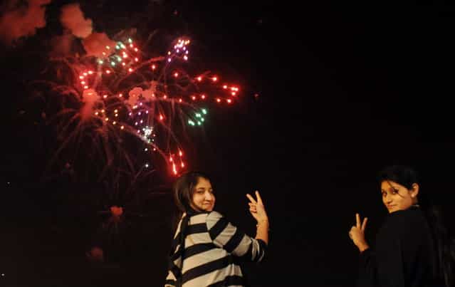 Pakistani girls pose for a photograph during a fireworks display at Clifton Beach in Karachi to celebrate the New Year early on January 1, 2013. (Photo by Asif Hassan/AFP Photo)