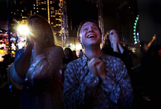 Performers react as fireworks explode over the Singapore financial district to mark the start of the new year. (Photo by Wong Maye-E/Associated Press)