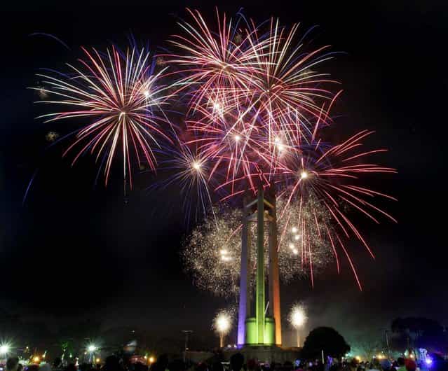 Spectators watch a fireworks display at the Quezon Memorial Circle in suburban Quezon city, north of Manila, Philippines. (Photo by Aaron Favila/Associated Press)