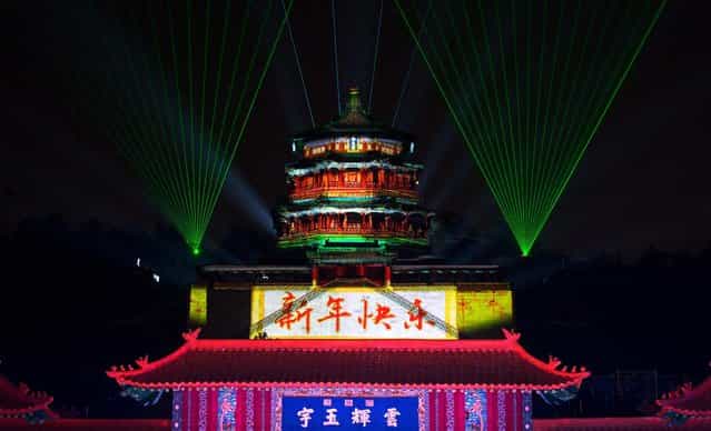 The pavilion of the Summer Palace is illuminated with lights and the words [Happy New Year] during a count-down event in Beijing. (Photo by Andy Wong/Associated Press)