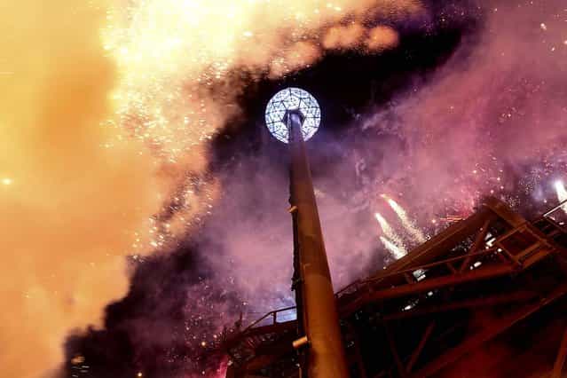 Fireworks explode as the Waterford crystal ball is raised at the beginning of Times Square New Year's celebrations. (Photo by Mary Altaffer/Associated Press)