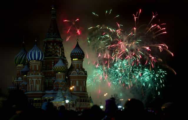 Fireworks explode over St. Basil Cathedral as people celebrate the new year in Moscow's Red Square. (Photo by Ivan Sekretarev/Associated Press)