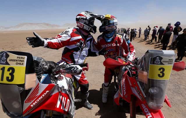 Honda riders Gerard Farres Guell of Spain, left, and Helder Rodrigues of Portugal talk at the end of the special stage of the 2013 Dakar Rally's 5th stage from Arequipa, Peru, to Arica, Chile on Wednesday, January 9, 2013. (Photo by Victor R. Caivano/Associated Press)