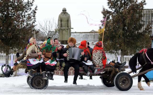 People sit on a horse-drawn cart as they attend Christmas celebrations in the town of Richev, some 290 km south from Minsk, on January 7, 2013. Orthodox Christians celebrate Christmas on January 7 in the Middle East, Russia and other Orthodox churches that use the old Julian calendar instead of the 17th-century Gregorian calendar adopted by Catholics, Protestants, Greek Orthodox and commonly used attendsin secular life around the world. (Photo by Viktor Drachev/AFP Photo)