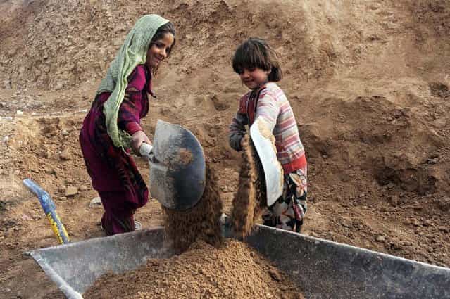 Afghan internal refugee children work at a traditional brick factory on the outskirts of Herat on January 7, 2013. In 2012 alone, spreading conflict in Afghanistan has forced more than 166,000 Afghans to flee their homes, bringing the total number of people internally displaced by conflict to at least 460,000 since the fall of the Taliban in late 2001 with conditions for the displaced falling well below international standards, according to a 2012 study by the Norwegian Refugee council. (Photo by Aref Karimi/AFP Photo)