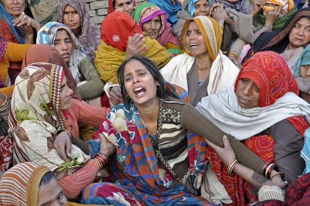 Dharamvati (C), wife of Indian soldier Hemraj Singh, weeps outside her house before Singh's body was brought for cremation in the Mathura district of the northern Indian state of Uttar Pradesh January 9, 2013. India denounced Pakistan on Wednesday over a firefight in the disputed territory of Kashmir in which two Indian soldiers were killed, but the nuclear-armed rivals both appeared determined to prevent the clash escalating into a full diplomatic crisis. (Photo by Reuters/Stringer) Dharamvati (C), wife of Indian soldier Hemraj Singh, weeps outside her house before Singh's body was brought for cremation in the Mathura district of the northern Indian state of Uttar Pradesh January 9, 2013. India denounced Pakistan on Wednesday over a firefight in the disputed territory of Kashmir in which two Indian soldiers were killed, but the nuclear-armed rivals both appeared determined to prevent the clash escalating into a full diplomatic crisis. (Photo by Reuters/Stringer)