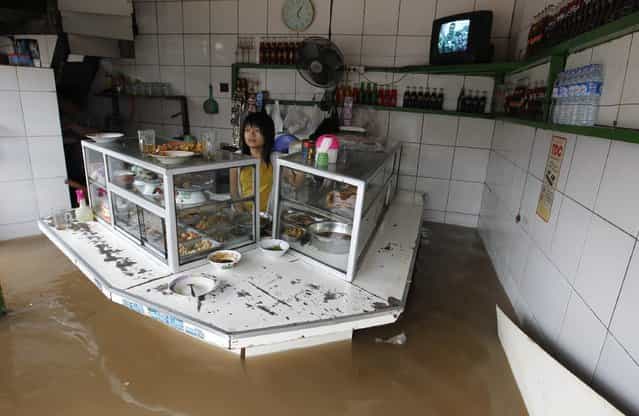 A woman stands in her food stall in the flooded business area in Jakarta January 17, 2013. Heavy monsoonal rains triggered severe flooding in large swathes of the Indonesian capital Jakarta on Thursday, with many government offices and businesses forced to closed because staff could not get to work. Weather officials warned the rains could get worse over the next few days and media reports said that thousands of people in Jakarta and its satellite cities had been forced to leave their homes because of the torrential downpours this week. (Photo by Enny Nuraheni/Reuters) A woman stands in her food stall in the flooded business area in Jakarta January 17, 2013. Heavy monsoonal rains triggered severe flooding in large swathes of the Indonesian capital Jakarta on Thursday, with many government offices and businesses forced to closed because staff could not get to work. Weather officials warned the rains could get worse over the next few days and media reports said that thousands of people in Jakarta and its satellite cities had been forced to leave their homes because of the torrential downpours this week. (Photo by Enny Nuraheni/Reuters)