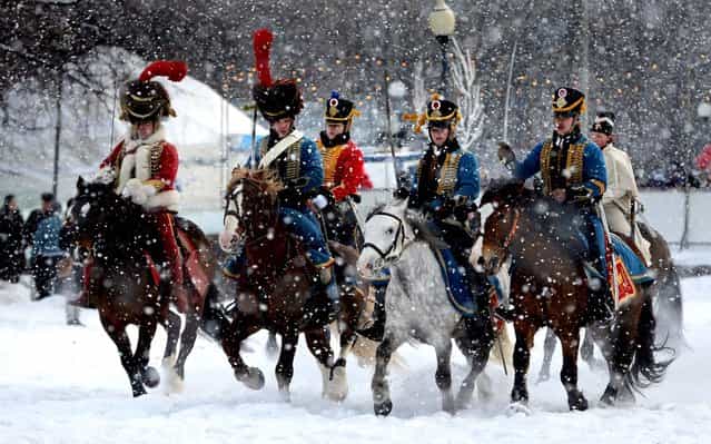 Historical re-enactors dressed as 1812-era French horsemen ride during a reenactment of the French Invasion of Russia in 1812, during celebrations to mark the Russian Orthodox Christmas in St. Petersburg, Russia, on January 7, 2013. Christmas falls on January 7 for Orthodox Christians who rely on the old Julian calendar rather than the Gregorian calendar adopted by Catholics and Protestants and commonly used in secular life around the world. (Photo by Dmitry Lovetsky/Associated Press)