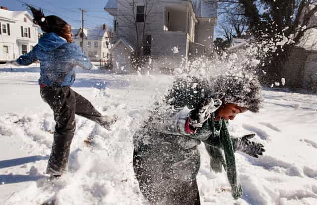 Satoria Ginn throws snow at Desiree Lyons along Laurel Street in Pocomoke City, Maryland, January 24, 2013. The snow was very dry, making snowballs hard to make, so they settled for throwing snow at each other. (Photo by Grant L. Gursky/The Daily Times)