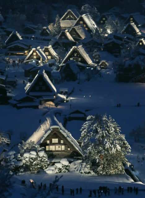 Japanese traditional wooden houses [Gassho zukuri], are lit up in the snow-covered village of Shirakawa in Gifu prefecture, central Japan on January 19, 2013. The Gassho zukuri farmhouses were listed as one of the World Heritage by UNESCO in 1995, and the village will be illuminated until February 16. (Photo by JiJi Press/AFP Photo)