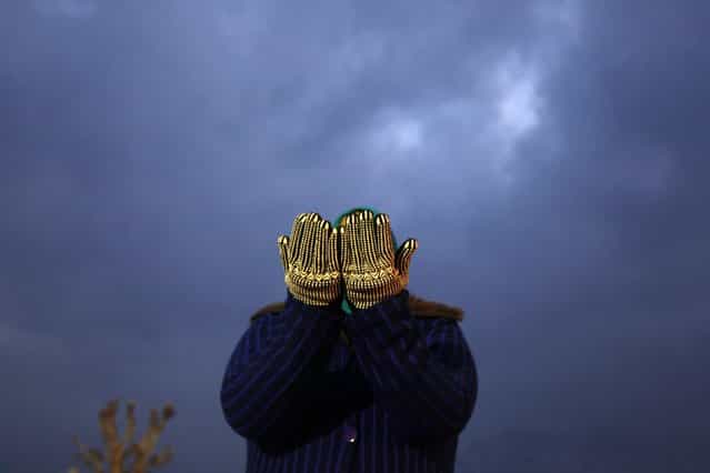 A Kashmiri Muslim woman prays on a cold winter morning during the festival of Eid-e-Milad at Hazratbal shrine in Srinagar January 25, 2013. Thousands of Kashmiri Muslims on Friday thronged to the shrine of Hazratbal, which houses a relic believed to be a hair from the beard of Prophet Mohammad, to celebrate Eid-e-Milad or the Prophet's birth anniversary. (Photo by Danish Ismail/Reuters)