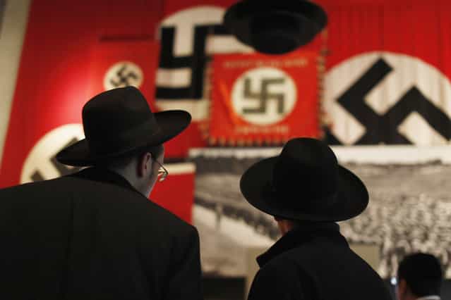 Ultra-Orthodox Jewish visitors look at a display of Nazi flags at Yad Vashem's Holocaust History Museum in Jerusalem January 25, 2013, ahead of International Holocaust Remembrance day which will be marked on January 27. (Photo by Amir Cohen/Reuters)