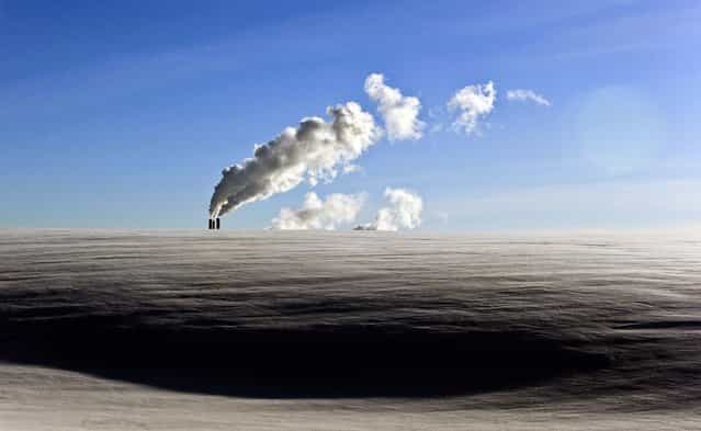 Steam rises from a heating plant rises in the below freezing temperatures in Minsk, Belarus, on January 23, 2013. (Photo by Sergei Grits/Associated Press)