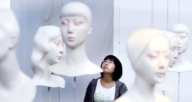 An attendee looks at art work at a gallery in Beijing. (Photo by Liu Jin/AFP Photo)