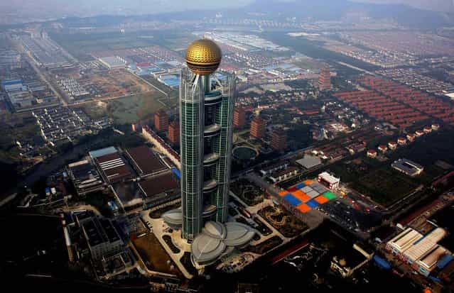 The skyscraper tower screams for attention over the village's otherwise flat skyline. (Photo by Carlos Barria/Reuters)
