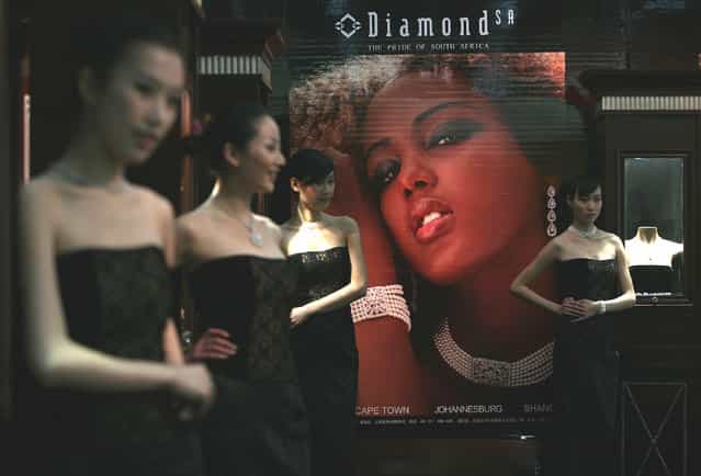 Models promote jewelry during a leading watch and jewelry show at the Three Gorges Museum in Chongqing Municipality, China. (Photo by China Photos)