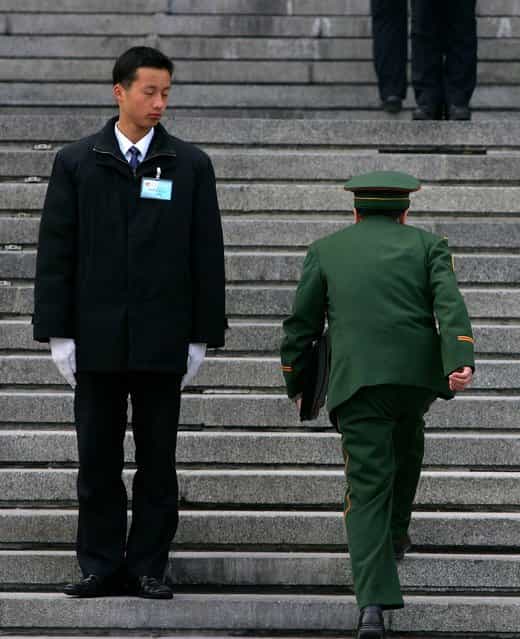 A military delegate (R) arrives at the Great Hall of the People for the fourth plenary session of the National People's Congress, or parliament in Beijing, China. (Photo by Guang Niu)