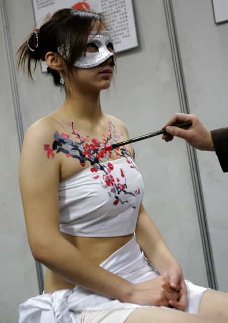A body-painting artist paints a model during the first Xian Sex Culture Festival in Xian of Shaanxi Province, China. (Photo by China Photos)