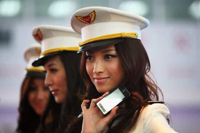 Chinese models show the new types of 3G mobile phones at the P&T/Wireless & Networks Comm China, the largest telecom event in Asia, in Beijing, China. (Photo by Feng Li)