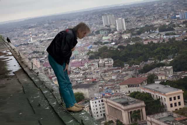 Alain Robert known as [Spiderman], looks over the edge from the roof of the Habana Libre hotel in Havana, Cuba, Friday, February 1, 2013. Robert, from France, plans to climb the 27 floor hotel on Monday. (AP Photo/Ramon Espinosa)