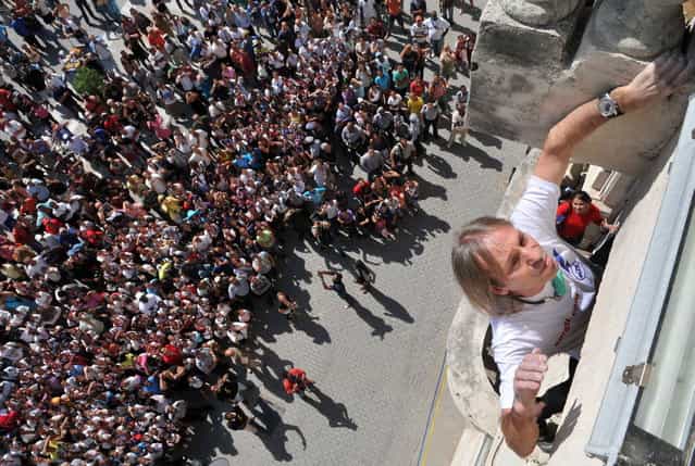 Alain Robert of France, who is known as "Spiderman", climbs up a school in the old quarters of Havana February 5, 2013. Robert, who scales buildings all over the world without safety equipment, climbed up the school on Tuesday, making his way up another historic building in Old Havana. He had climbed the landmark Havana Libre hotel on Monday. REUTERS/Stringer (CUBA - Tags: SOCIETY EDUCATION)