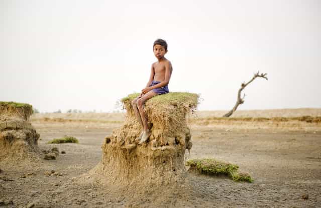 [Ghoramara island is located on a delta region in West Bengal. Due to the dramatic increase in sea level, resulting from the effects global warming since the 1960s, the shores of this island are being perpetually washed away. Since the 1980s more than 50% of the territory has vanished due to erosion by the sea. Many of the people still living on the island are farmers and fishermen who depend on the island's resources for their livelihoods. According to a civil servant I met, in 20-25 years the Indian government could abolish the island and has already formulated a plan to evacuate villagers to another island named Sagar. However, this evacuation plan does not ensure any financial support or compensation for those having to relocate their lives. I situated villagers on the shore and took portraits of them in juxtaposition with the beauty of the vanishing island. There will come a day when these people will have no choice but to move out of their homeland]. (Photo and comment by Daesung Lee, Korea/2013 Sony World Photography Awards