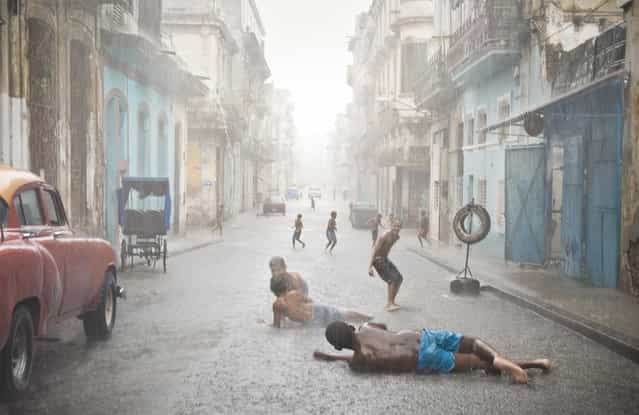 [Havana, Cuba. Havana weather in July and August counts as brutally hot. Short but heavy rains are very common and welcomed by locals, especially kids]. (Photo and comment by Val Proudkii, USA/2013 Sony World Photography Awards