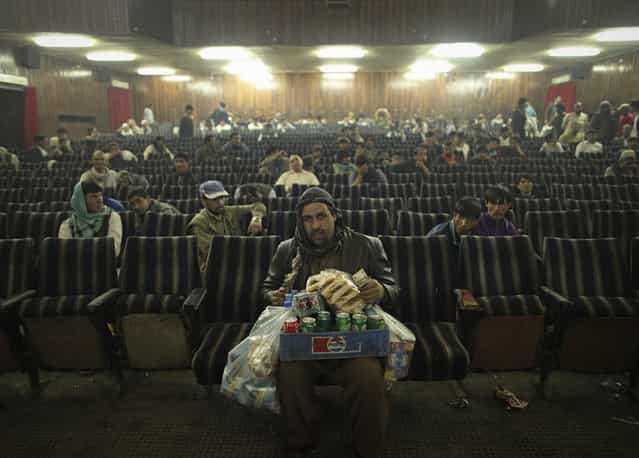 [An employee of Cinema Pamir sells refreshments during the movie intermission in Kabul, Afghanistan, on May 3, 2012. Once a treasured luxury for the elite, Afghan cinemas are dilapidated and reflect an industry on the brink of collapse from conflict and financial neglect. Kabul's cinemas show Pakistani films in Pashto, American action films and Bollywood to rowdy, largely unemployed crowds in pursuit of any distraction from their drab surroundings]. (Photo and comment by Danish Siddiqui/Reuters, India/2013 Sony World Photography Awards