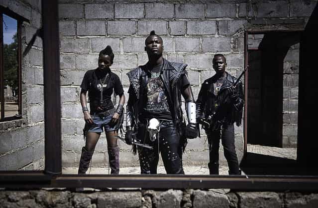 [Edith, Hellrider, and Dadmonster pose for a photograph. In Botswana, heavy metal music has landed. Metal groups are now performing in nightclubs, concerts, festivals. The ranks of their fans have expanded dramatically. These fans wear black leather pants and jackets, studded belts, boots and cowboy hats. On their t-shirts stand out skulls, obscenities, historical covers of hard-rock groups popular in the seventies and eighties, such as Iron Maiden, Metallica, and AC/DC. They have created their own style, inspired by classic metal symbolism, but also borrowing heavily from the iconography of western films and the traditional rural world of Botswana. Their nicknames, Gunsmoke, Rockfather, Carrott Warmachine, Hellrider, Hardcore, Dignified Queen, may appear subversive and disturbing as their clothing, but they are peaceful and gentle. [We like to get dressed, drink meet friends and feel free, this music is so powerful. We are lucky to live in a country tolerant and open] argues one of the leaders. A precious rarity for Africa]. (Photo and comment by Daniele Tamagni, Italy/2013 Sony World Photography Awards