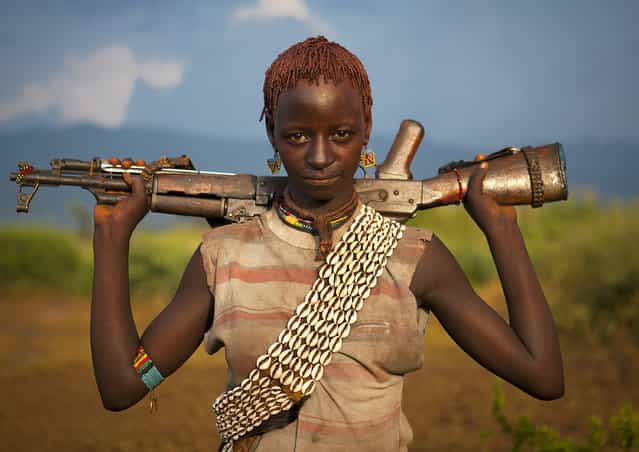 [Bana girl with gun – Omo valley Ethiopia. If you like girls with guns, go south Ethiopia! They are very nice to see! But when you know that they are totally drunk as it is part of a bull jumping ceremony, you feel a little bit unsafe!]. (Photo and comment by Eric Lafforgue)