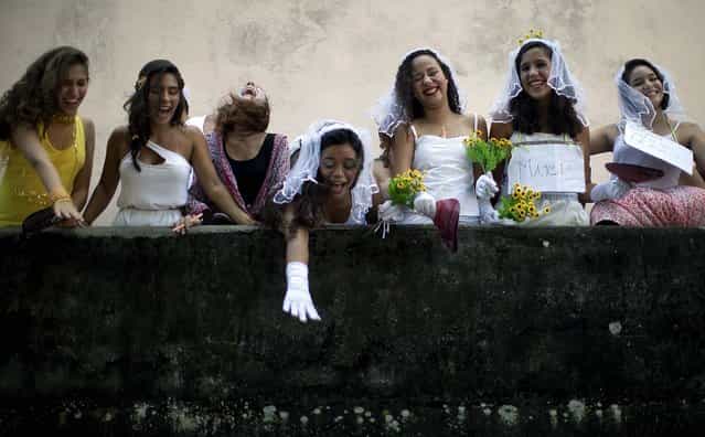 Revelers participate in the [Carmelitas] street parade in Rio. [Carmelitas] is a band started in 1990 by a group of friends who gathered for soccer and drinks just outside a Carmelite convent. Jokes about the possibility of nuns escaping to join the party gave rise to the band, which parades twice: once at the beginning of Carnival and then on the last day. (Photo by Felipe Dana/Associated Press)
