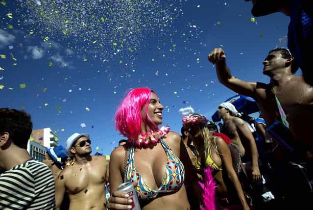 Confetti rains down on a group of revelers at the Simpatia e Quase Amor block party in Rio. (Photo by Silvia Izquierdo/Associated Press)