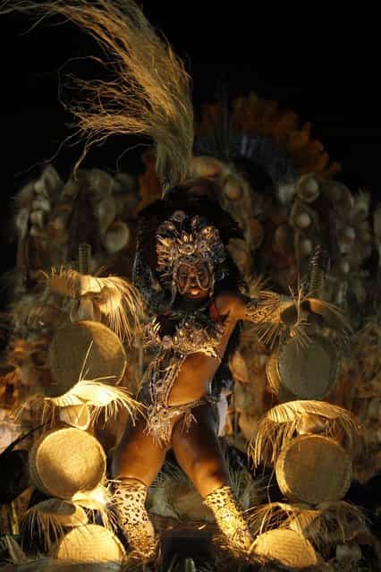 A reveller from Uniao de Jacarepagua samba school dances atop a float during the second night of the A Group annual Carnival parade in Rio de Janeiro's Sambadrome February 9, 2013. The samba school which wins the A Group will parade with the top samba groups at the Special Group performance in 2014. (Photo by Pilar Olivares/Reuters)