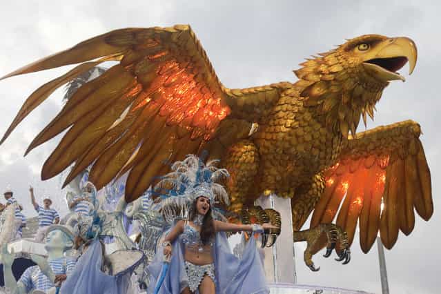 A dancer from the Aguia de Ouro samba school performs on a float during a carnival parade in Sao Paulo, Brazil, Saturday, February 9, 2013. (Photo by Andre Penner/Associated Press)