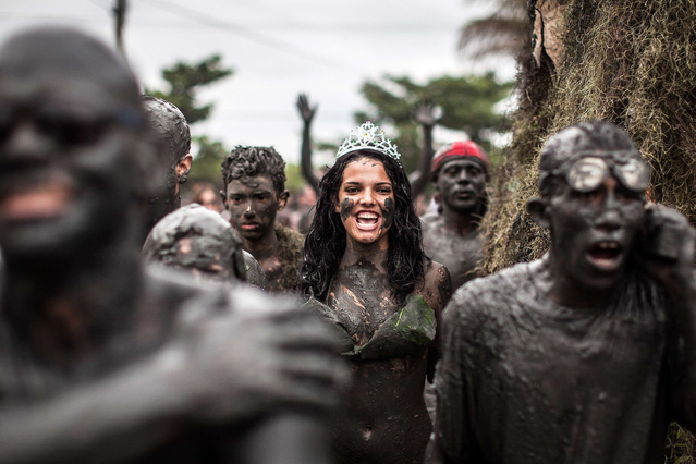 Revelers participate in the traditional Bloco da Lama (Mud block) carnival in Parati, Rio de Janeiro State, Brazil, on February 9, 2013. The event, which was begun by two men in a playful manner in 1986, has now become a traditional carnival in which participants disguised as primitives with rags, lianas or skulls and bones, dive in the mud. (Photo by Victor Moriyama/AFP Photo)