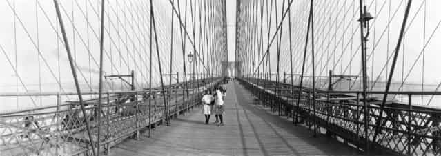 [Pedestrians on the upper deck promenade of Brooklyn Bridge, 1910]. (Photo by an unknown photographer)