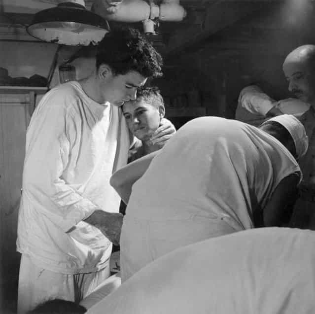 [Pvt. J.B. Slagle, USA, receives his daily dressing of wounds on board USS SOLACE enroute from Okinawa to Guam, May 1945]. (Photo by Lt. Victor Jorgensen)