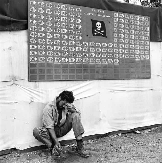 [Tired member of VF-17 pauses under the squadron scoreboard at Bouganville], February 1944. (Photo by Charles Fenno Jacobs)