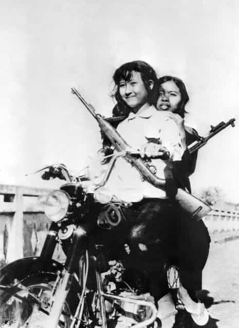 Women soldiers ride a Japanese motorcycle in the streets of the Cambodian capital of Phnom Penh, in April 1975. On New Year's Day 1975, Communist troops led by Pol Pot and Ieng Sary, launched an offensive to oust Lon Nol's Khmer Republic. The Lon Nol governement in Phom Penh surrendered 17 April 1975 after 117 days of the hardest fighting of the war. Immediately after its victory, the PCK ordered the evacuation of all cities and towns. Many of the foreigners and some Cambodians, who couldn't or wouldn't flee Cambodia, took refuge at the embassy from which they were taken by truck to Thailand two weeks later. (Photo by STF/AFP Photo)