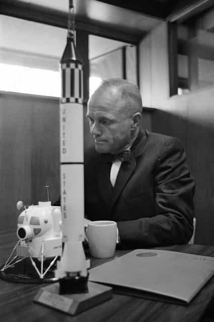In this February 8, 1963 file photo, astronaut John Glenn sits with models of the Mercury spacecraft atop its launch rocket and a lunar module, representing the past and the future of space exploration as he talks about the first anniversary of his historic flight. (Photo by AFP Photo)