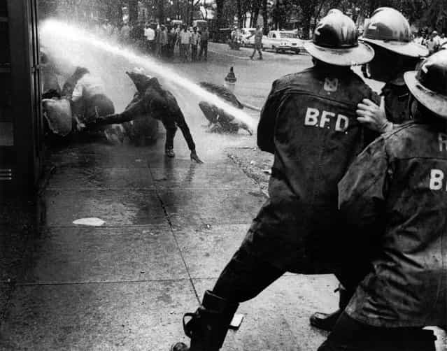 Firefighters turn their hoses full force on civil rights demonstrators in Birmingham, Alabama, on July 15, 1963. (Photo by Bill Hudson/AP Photo)