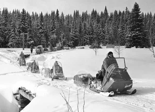 Powered sledges break a trail through Maine's primitive Allagash Forest, on March 5, 1963. Twenty men, led by an expert on Arctic equipment, made an extended trip through the forest to test equipment. Robert Faylor, director of the Arctic Institute of North America, led the group. The sledges, called Polaris vehicles, are powered with engines about the size of an outboard motor and travel up to 8 or 10 miles an hour, depending on snow conditions. (Photo by Dan Grossi/AP Photo)