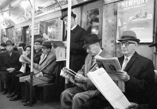 Riders read their morning newspapers on New York's subway en route to work, on April 1, 1963 after the end of the city's 114-day newspaper strike. (Photo by Jacob Harris/AP Photo)
