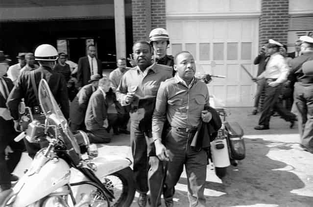 Rev. Ralph Abernathy, left, and Rev. Martin Luther King Jr., are removed by a policeman as they led a line of demonstrators into the business section of Birmingham, Alabama, on April 12, 1963. (Photo by AP Photo)
