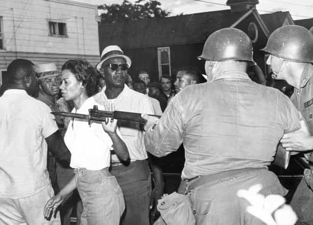Mrs. Gloria Richardson, head of the Cambridge Nonviolent Action Committee, pushes a National Guardsman's bayonet aside as she moves among a crowd of African Americans to convince them to disperse, in Cambridge, Maryland, on July 21, 1963. (Photo by AP Photo)