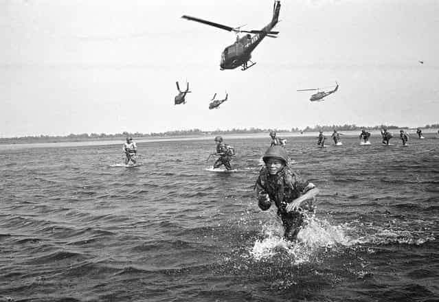 One trooper sprawls in the flooded swamp as other Vietnamese Government Soldiers walk through the water after landing from U.S. army Helicopters near CA Mau Peninsula in South Vietnam on September 15, 1963. The Soldiers were landed to pursue communist Viet Cong Guerrillas who had attacked a Vietnamese outpost. (Photo by Horst Faas/AP Photo)